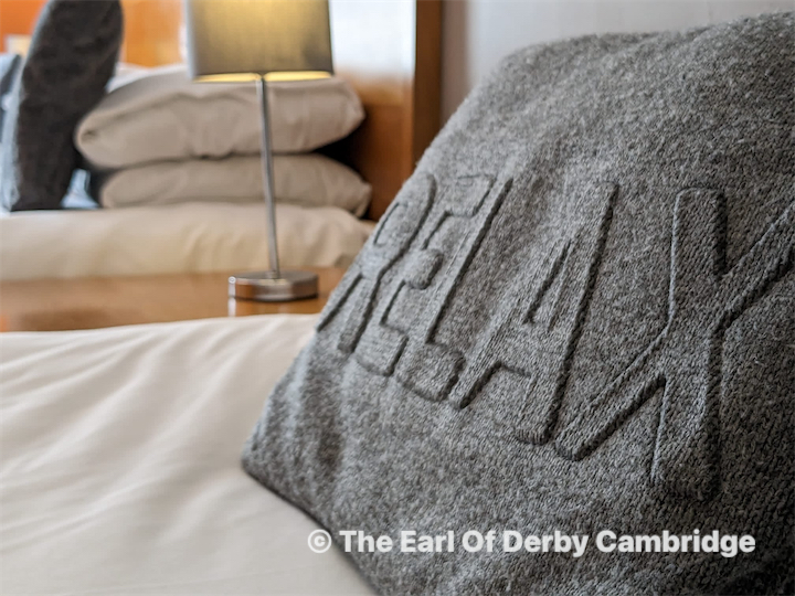 man watching a band on the stage wearing a red t-shirt and black hat.